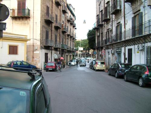 a city street with cars and a person riding a bike at La Terrazza della Nonna in Palermo