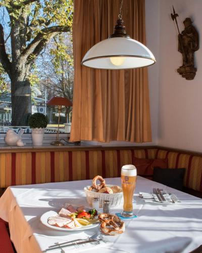 a table with a plate of food and a glass of beer at Hotel und Gasthof Soller in Ismaning