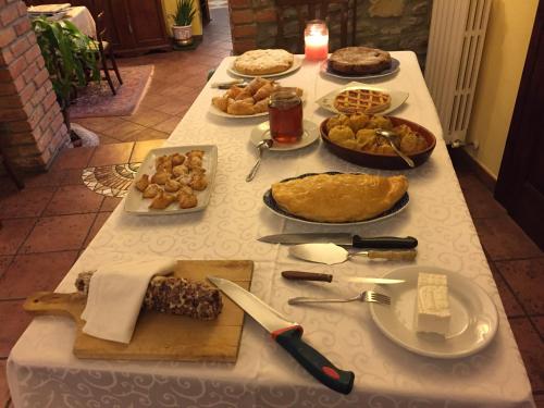 une table avec un tissu de table blanc et de la nourriture dans l'établissement Agriturismo Casa Castellini, à Garbagna