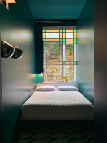 - une chambre bleue avec un lit et une fenêtre dans l'établissement PrimoPianoPosillipo, à Naples