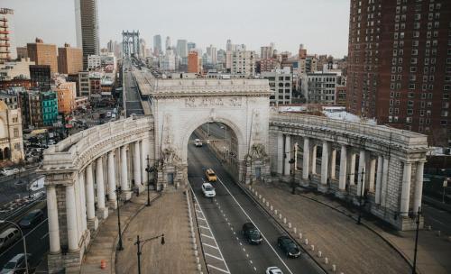 a large building with an arch in a city at Leon Hotel LES in New York