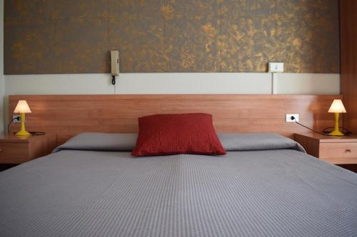 a bedroom with a bed with a red pillow on it at Albergo Al Pescatore in Brenzone sul Garda