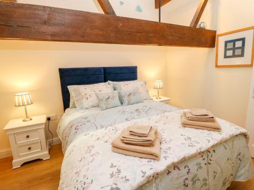 a bedroom with a bed with towels on it at The Loft Apartment in Todmorden