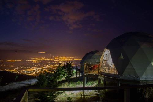 two domes on top of a hill at night at Natura Glamping in Alcongosta