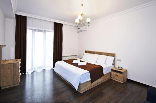 a hotel room with a bed and a chandelier at Patriott Hotel in Yerevan