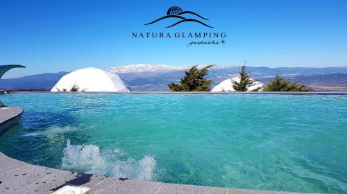 a view of a pool of water with mountains in the background at Natura Glamping in Alcongosta