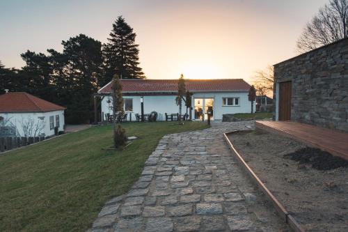 a house with a stone walkway in front of a yard at Natura Glamping in Alcongosta