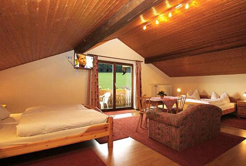 a bedroom with a bed and a chair and a table at Gästehaus Annemarie in Rimsting