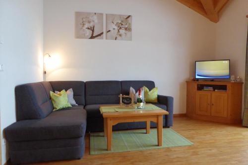 a living room with a blue couch and a table at Ferienwohnung Bolsterlang in Bolsterlang