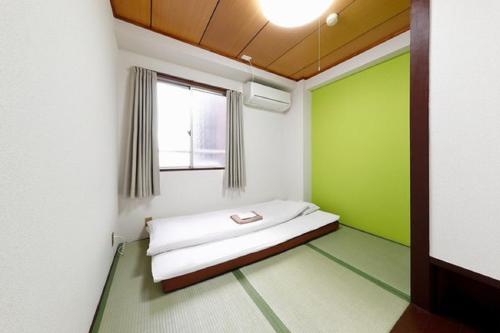 大阪市にあるOsaka - Hotel / Vacation STAY 23790の緑と白の壁のベッドルーム1室(ベッド1台付)