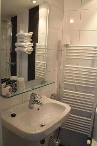 a bathroom with a sink and a mirror and towels at De Doelen in Leiden