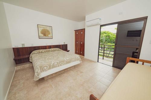 a bedroom with a bed and a sliding glass door at Parador Tropical in Bombinhas