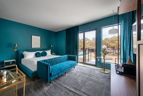 a bedroom with blue walls and a bed with a blue couch at The Ruby Hotel in Round Rock