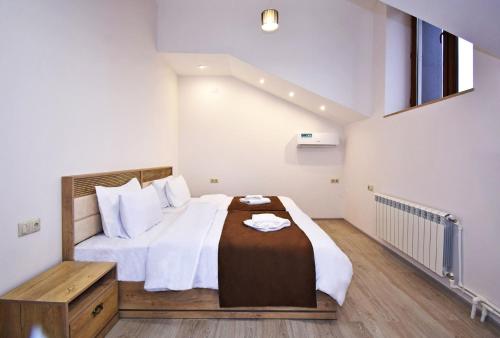 a bedroom with a large bed with a wooden floor at Patriott Hotel in Yerevan