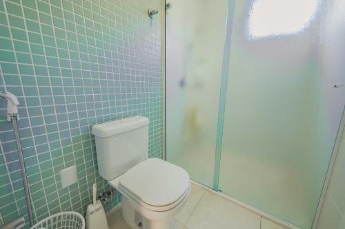 a bathroom with a toilet and a glass shower at Parador Tropical in Bombinhas
