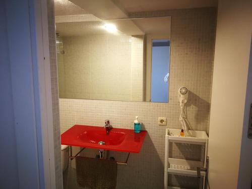 a bathroom with a red sink and a mirror at Habitaciones Turisticas Las Brisas in Valencina de la Concepción