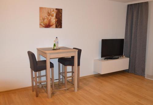 ニュルンベルクにあるModernes 1-Zimmer Apartment W-Lan, Stellplatzの小さなテーブル(椅子2脚付)、テレビが備わります。