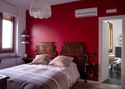 a bedroom with a red wall with a bed at Lirma B&B in Cefalù