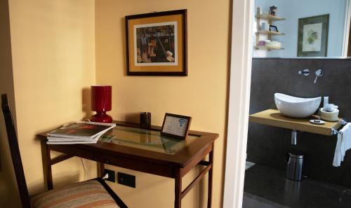 a bathroom with a glass table and a sink at Lirma B&B in Cefalù