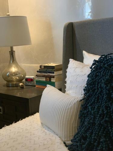 a bed with a pillow and a lamp on a table at The Meridian at Lighthouse Point in West Bay