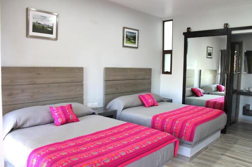 a hotel room with two beds with pink sheets at Quinta Huizache in Santa María Nopaltepec