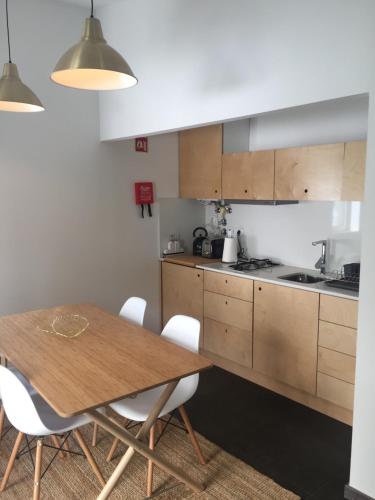 a kitchen with a wooden table and white chairs at Casa do Muro in Coimbra