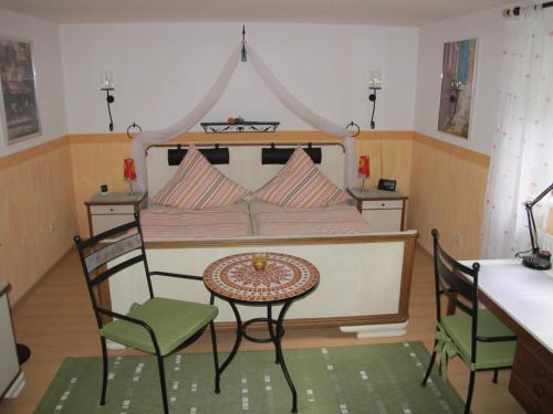 a bedroom with a bed with a table and chairs at Pension Geva in Warendorf