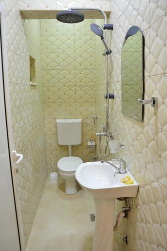 a bathroom with a sink and a toilet and a mirror at Guest House Vera in Ulcinj