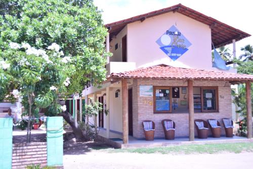 a building with chairs in front of it at Pousada Lua Cheia in Japaratinga