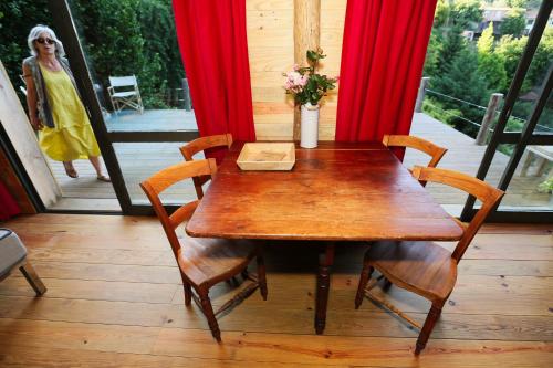 a wooden table and chairs on a porch with red curtains at Ribeira Delos in Santa Marta de Penaguião