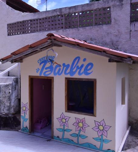 a sign on the side of a building with flowers on it at Pousada Lua Cheia in Japaratinga