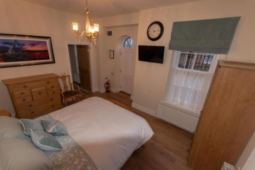 ein Schlafzimmer mit einem Bett und einer Uhr an der Wand in der Unterkunft The Gatelodge in Dungiven