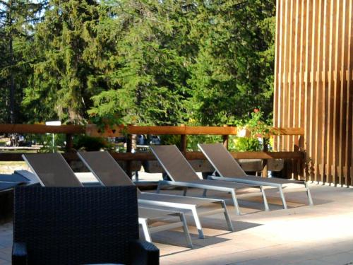 a group of lounge chairs sitting on a patio at Hotel Boton D'Or & Wellness a La Thuile in La Thuile