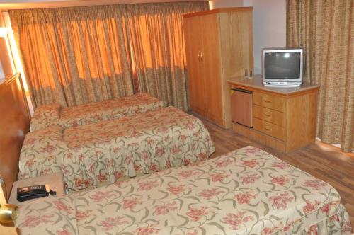 a hotel room with two beds and a television at Caesars Palace Hotel in Cairo