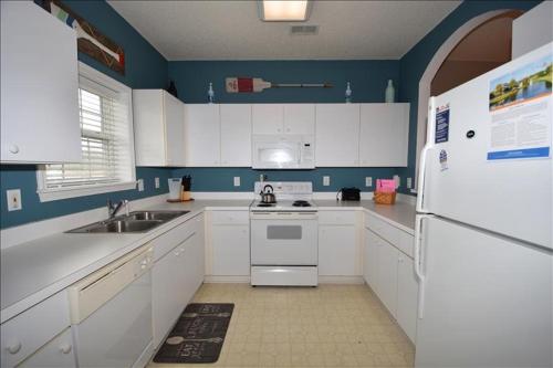 a kitchen with white cabinets and a white refrigerator at 113 Cypress Bend Condo in North Myrtle Beach
