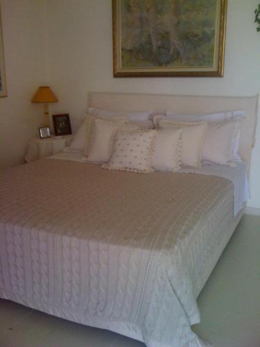 a bedroom with a large white bed with pillows at Nerantza Villa Jolimax in Nerántza