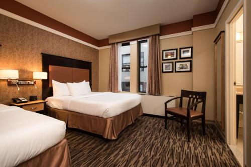 a hotel room with two beds and a chair at The Hotel at Fifth Avenue in New York