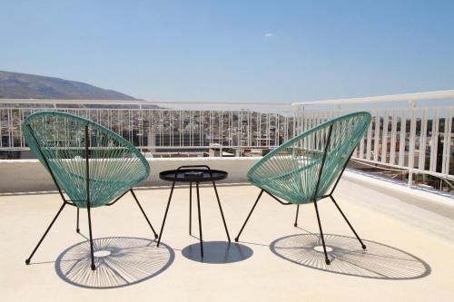 two green chairs and a table on a balcony at Homz AH02 Kolonaki Penthouse Studio in Athens