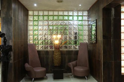 a lobby with two chairs and a vase with a tree at La Cour Hotels and Apartments Cooper in Lagos