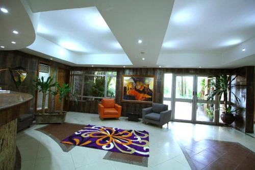 a large living room with an orange chair and a rug at La Cour Hotels and Apartments Cooper in Lagos
