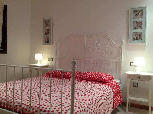 a bedroom with a red and white bed with two lamps at Apartment luxury complex with sea view in Adeje