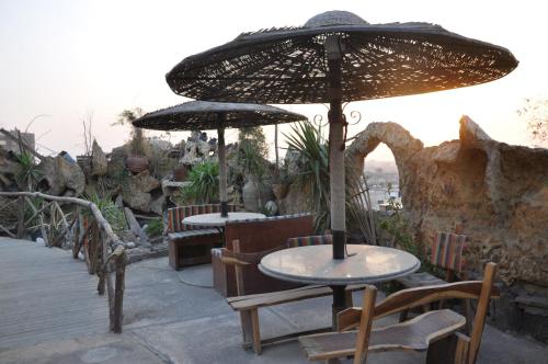 two tables and chairs under an umbrella on a patio at Caesars Palace Hotel in Cairo