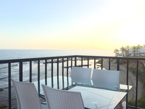 a balcony with a table and chairs and the ocean at Balcon Del Mar Primera Linea de Playa in La Cala de Mijas
