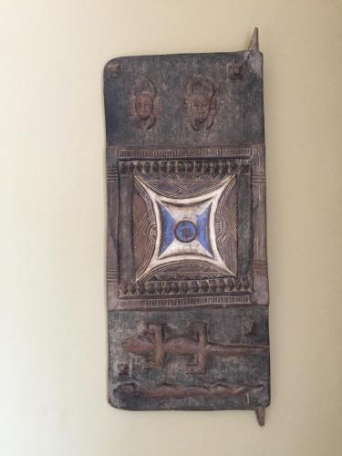 an ancient artifact with an eye on a wall at More Than A Drop in Moshi