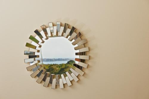a circular mirror on a wall with a view of a forest at Koura Bay Golf Resort in Kaikoura