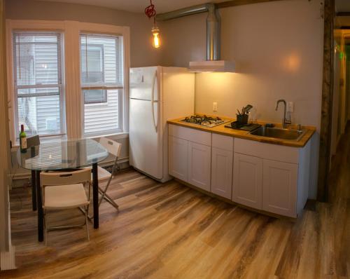 uma cozinha com uma mesa e um frigorífico branco em Boston Homestel em Boston