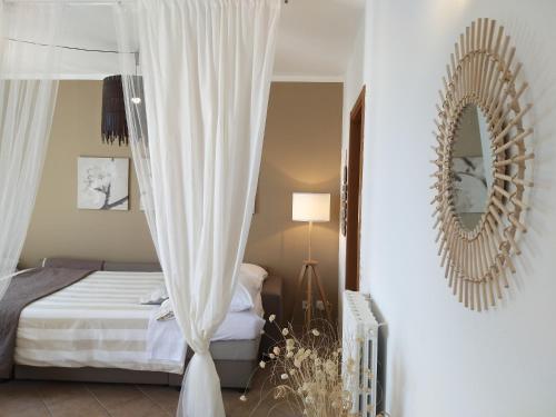 リオマッジョーレにあるSuite Riomaggioreのベッドルーム(天蓋付きベッド1台、鏡付)