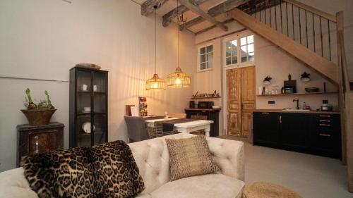 a living room with a couch and a kitchen at Cosy Cityhouse Leeuwarden in Leeuwarden