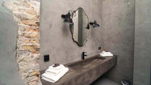 a bathroom with a sink with a mirror and towels at Cosy Cityhouse Leeuwarden in Leeuwarden
