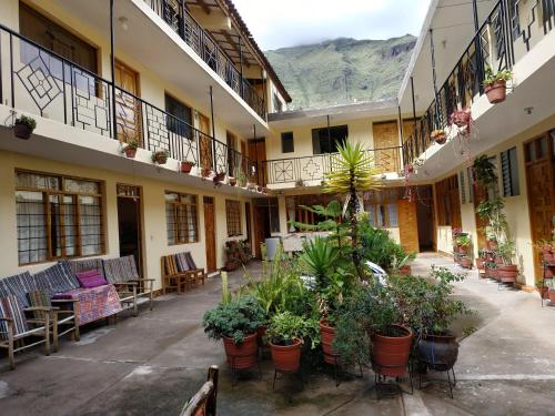 a courtyard of a building with chairs and plants at Hospedaje Inti in Pisac